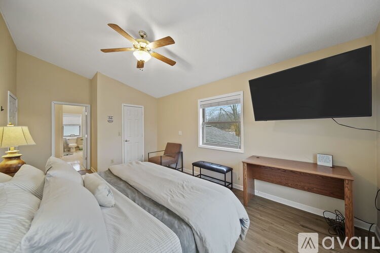 A bedroom with a bed, desk, and chair.
