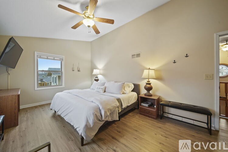 A bedroom with a large bed and a ceiling fan.