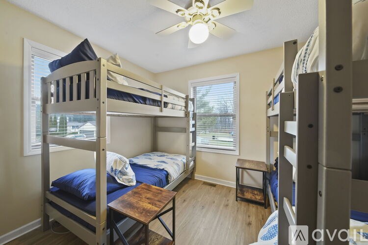 A room with bunk beds and a table in the middle.