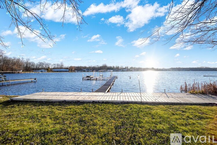 A sunny day at the lake with a dock in the foreground.