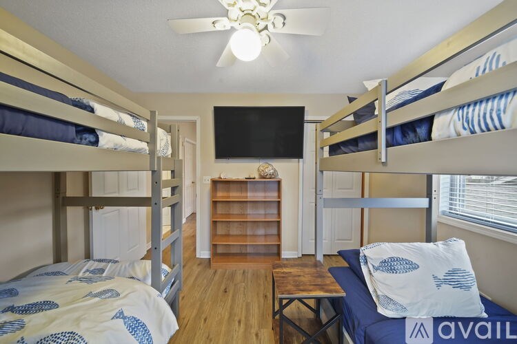 A room with bunk beds and a ceiling fan.