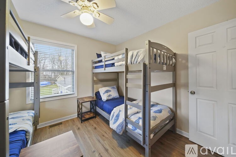 A bedroom with bunk beds and a ceiling fan.