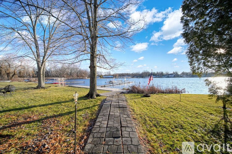 A walkway leads to a body of water with trees on either side.