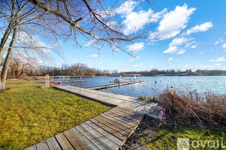 A wooden walkway leads to a body of water with boats docked on the shore.