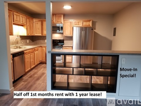 A kitchen with wooden cabinets and a refrigerator is on offer for rent.