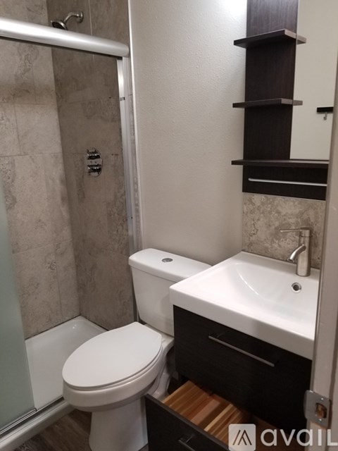 A bathroom with a toilet, sink, and shelves.