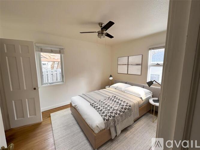 A bedroom with a large bed and a ceiling fan.