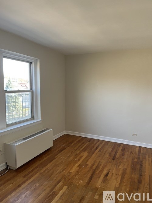 A room with wooden floors and a window with a white frame.