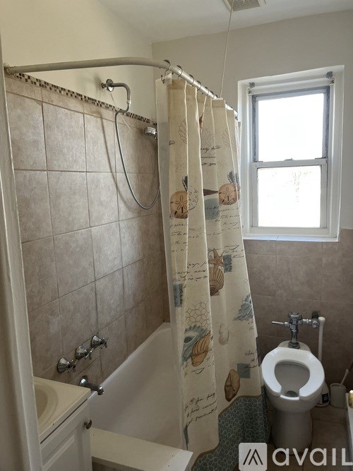 A bathroom with a toilet, sink, and shower.