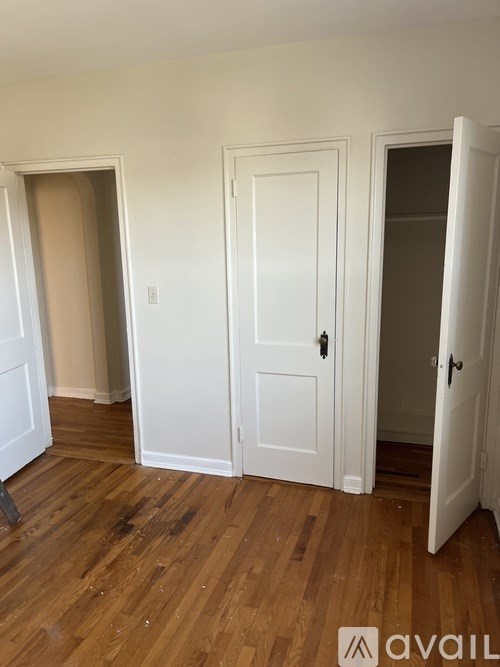 A room with white doors and wooden floors.