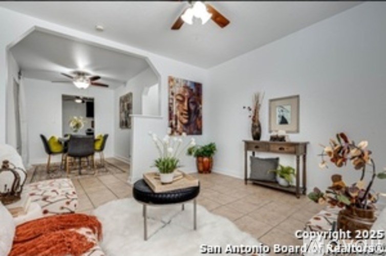 A living room with a black sofa and a wooden coffee table.