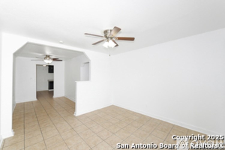 A room with a ceiling fan and tiled floor.