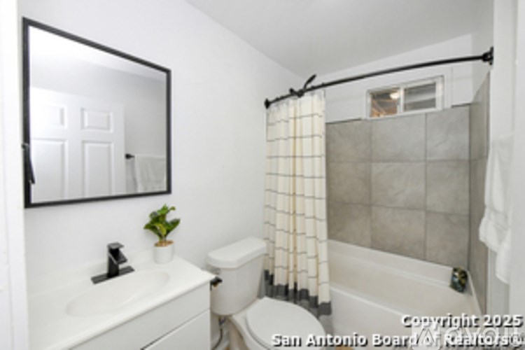 A bathroom with a toilet, sink, and shower.