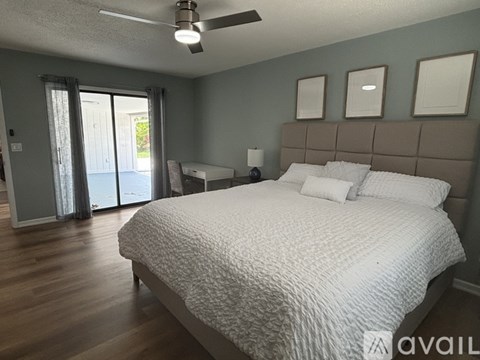 A bedroom with a large bed and sliding glass doors.