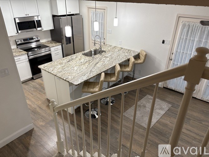 A kitchen with a granite countertop and a dining table with chairs.