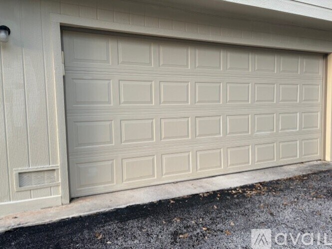 A white garage door with a grid pattern on the side.