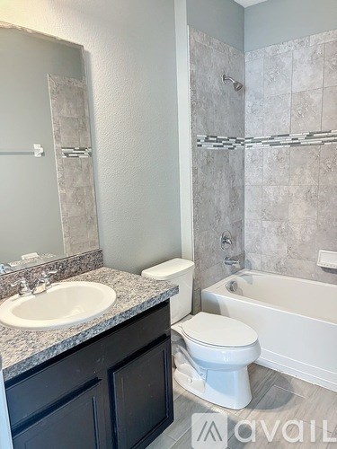 A bathroom with a toilet, sink, and bathtub.