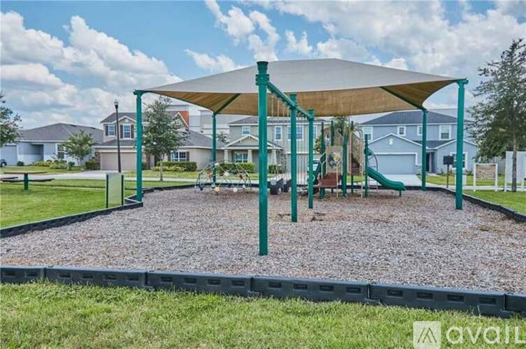 A playground with a green metal frame and a white canopy.