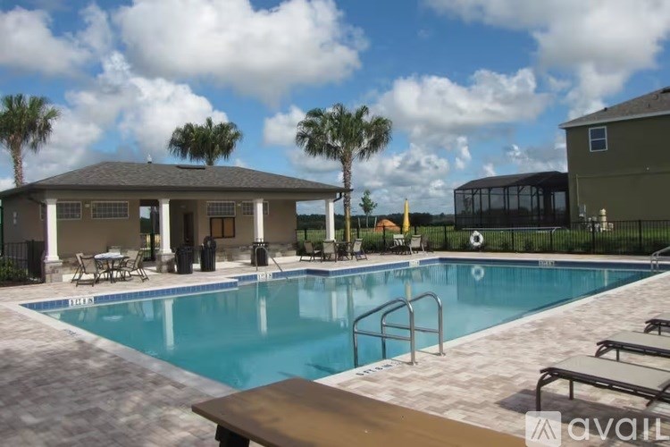 A pool with a slide and a house in the background.