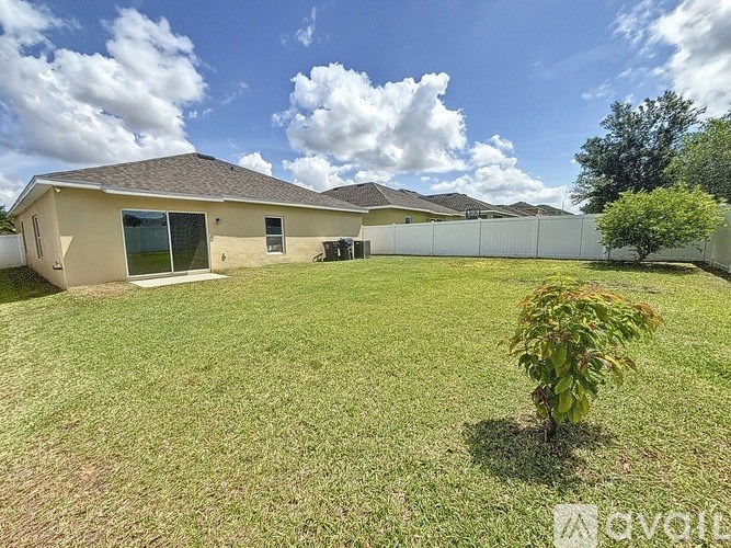 A house with a fence and a tree in the front yard.