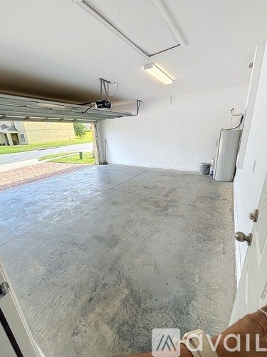 A large empty room with a concrete floor and white walls.