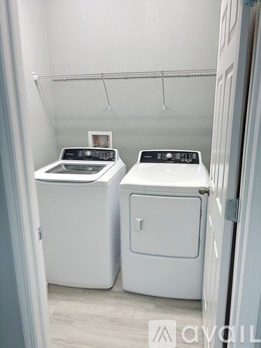 Two white front loading washing machines in a small laundry room.