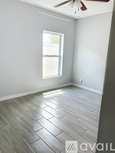 A room with a ceiling fan and a window.