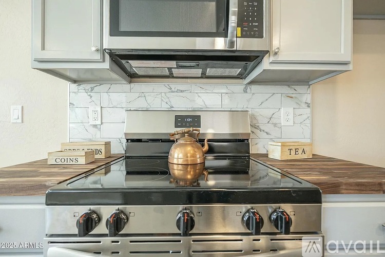 A modern kitchen with a stove top oven and a microwave above it.