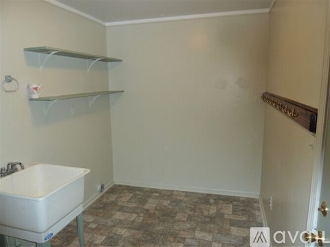 A small room with a sink and shelves.
