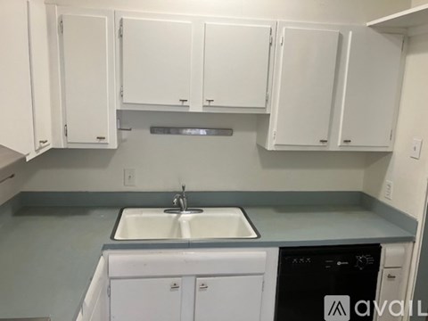 A kitchen with white cabinets and a dishwasher.