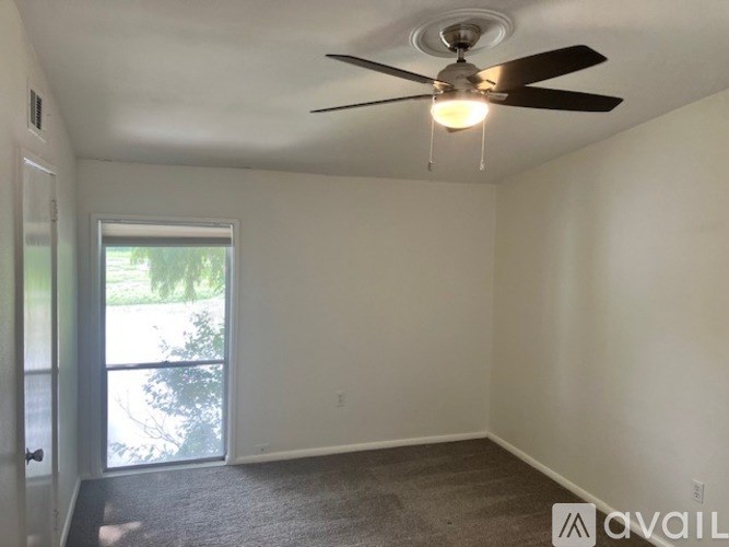 A room with a ceiling fan and a window.