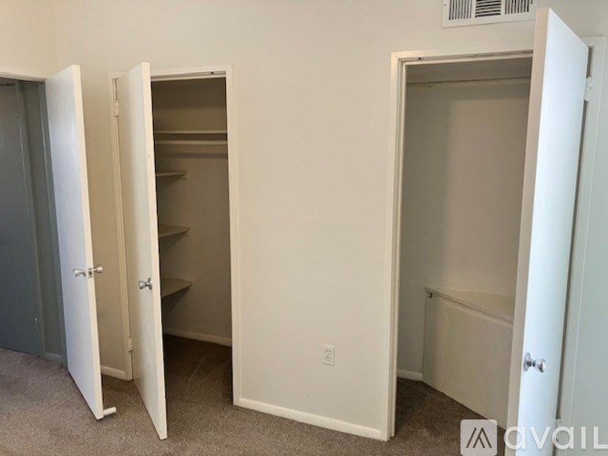 Three white closet doors are open.