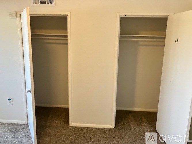 Two empty white closets in a room.