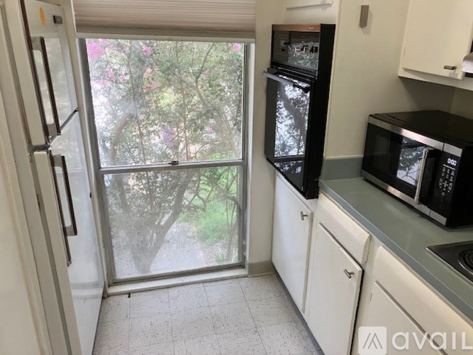 A kitchen with a refrigerator, microwave, and oven.