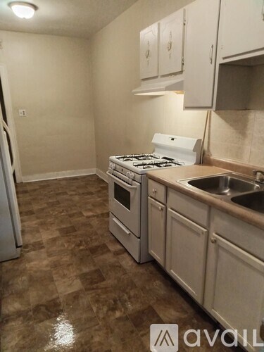 A kitchen with a white stove and a sink.