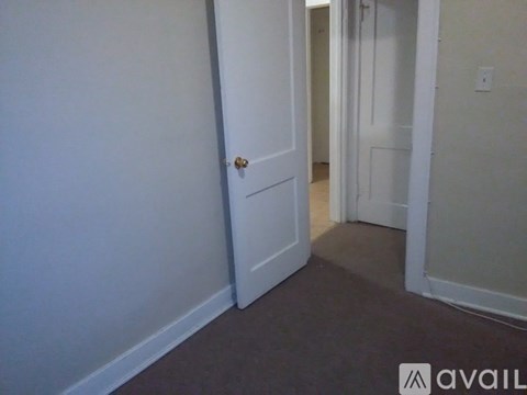 A room with a wooden floor and a window letting in sunlight.