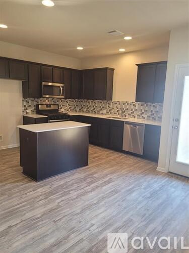 A kitchen with dark brown cabinets and a white island.