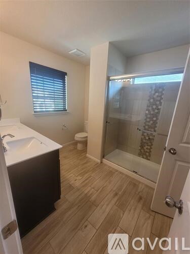 A bathroom with a sink, toilet, and shower.