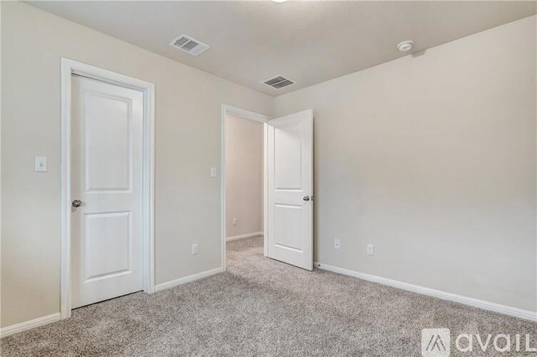 A room with two white doors and carpeted floor.