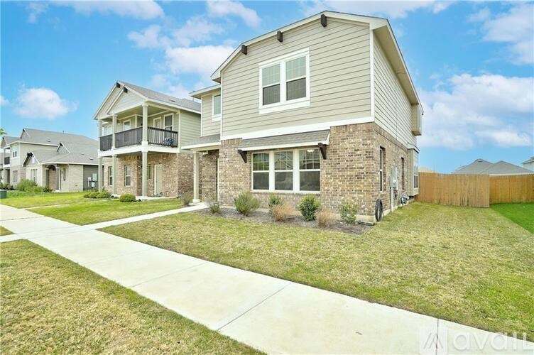 A house with a grey roof and a white fence.