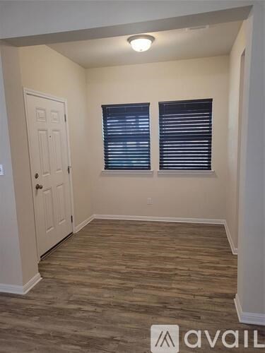 A room with a door and a window with blinds.