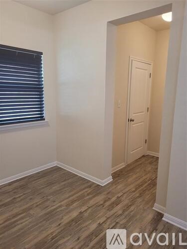 A room with wooden flooring and a white door.