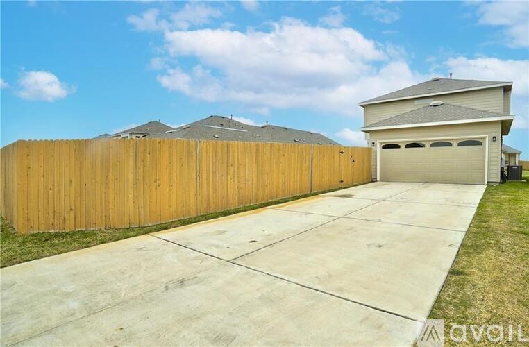 A house with a wooden fence and a garage door.