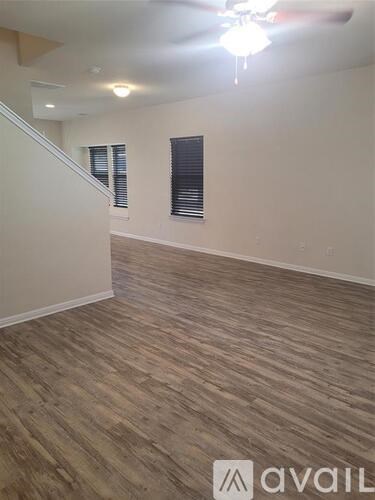 A room with wooden flooring and a ceiling fan.