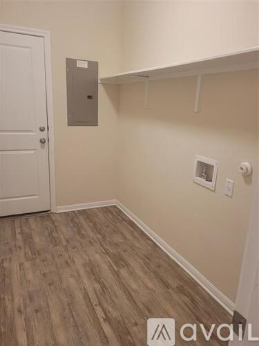 A room with a white door and a wooden floor.