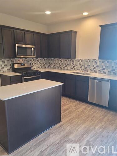 A kitchen with dark brown cabinets and a white countertop.