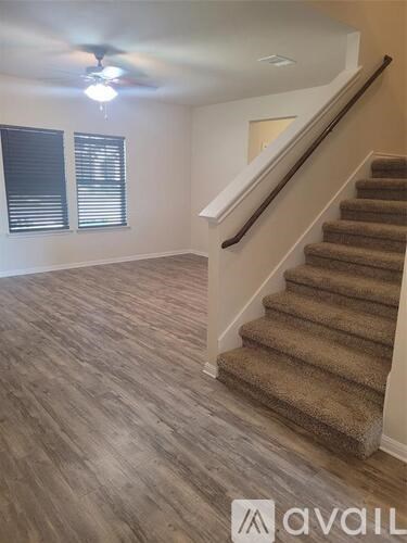 A room with a staircase and a ceiling fan.