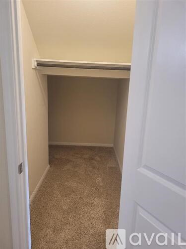 A small, empty room with a carpeted floor and white walls.