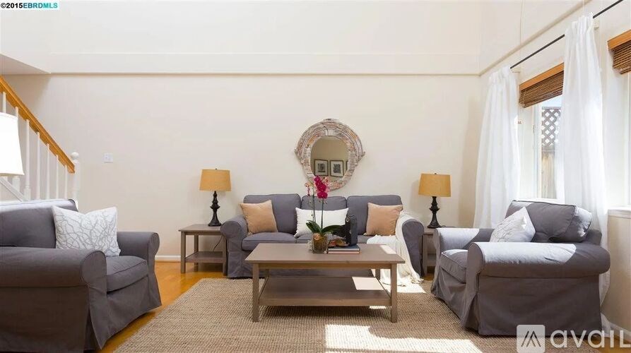 A living room with grey couches and a wooden coffee table.
