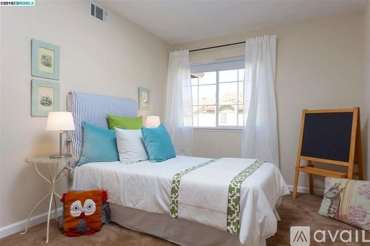 A bedroom with a white bed, a white lamp, a white chair, a white curtain, a white bedspread, a white pillow, a white wall, a white floor, a white ceiling, a white window, a